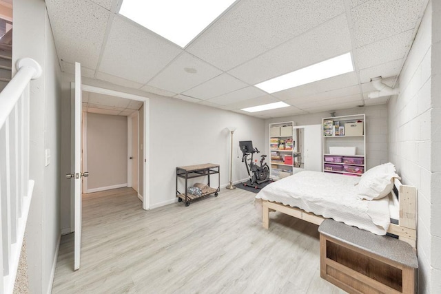 bedroom with a paneled ceiling and hardwood / wood-style flooring