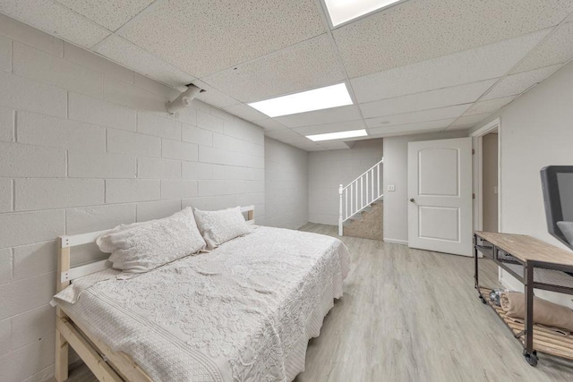 bedroom featuring light hardwood / wood-style flooring and a drop ceiling