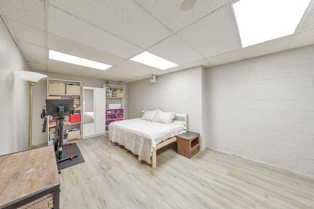 bedroom featuring a paneled ceiling and light wood-type flooring