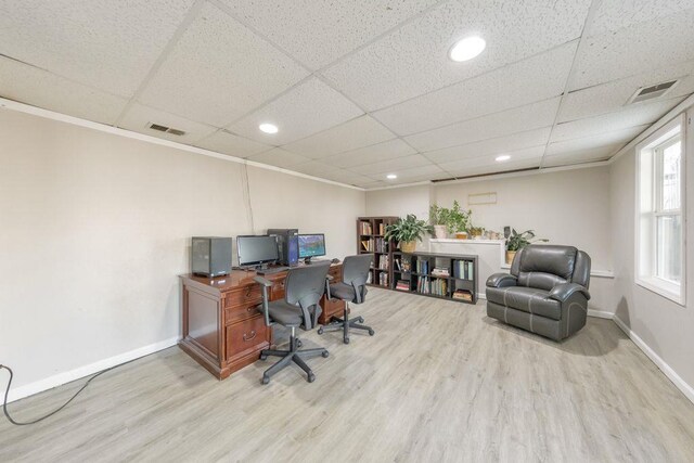 office area with hardwood / wood-style floors and a paneled ceiling