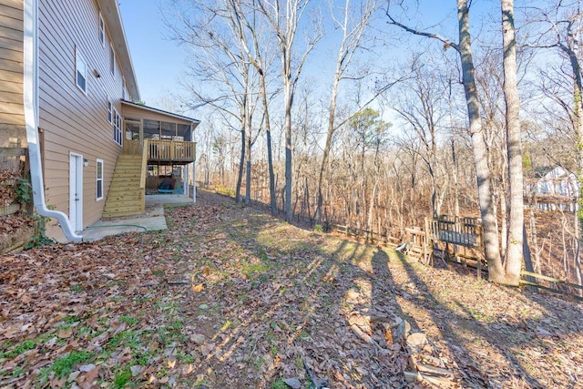 view of yard featuring a wooden deck and a sunroom