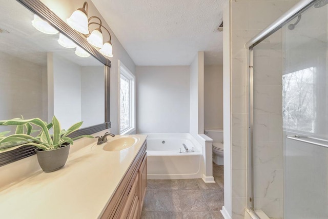 full bathroom featuring vanity, separate shower and tub, toilet, and a textured ceiling