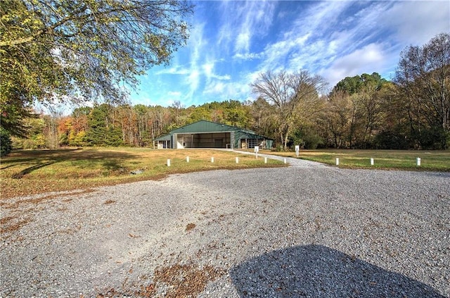 1195 Grady Rd, Rockmart, GA 30153 - view of front of home featuring a garage, a front yard, an outbuilding, a forest view, and a pole building