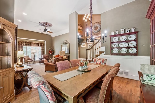 1042 Bailey Rd, Woodstock, GA 30188 - dining area with light wood finished floors, stairway, a chandelier, ceiling fan, and wainscoting