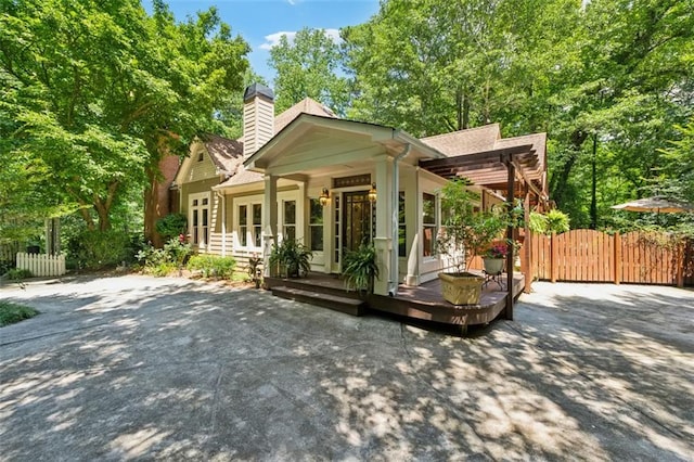 1042 Bailey Rd, Woodstock, GA 30188 - view of front facade featuring french doors, a gate, a chimney, a deck, and roof with shingles