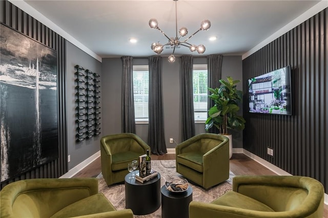 sitting room with hardwood / wood-style flooring, a notable chandelier, and ornamental molding