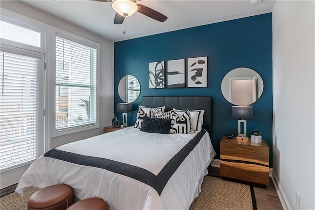 bedroom featuring multiple windows, hardwood / wood-style floors, and ceiling fan