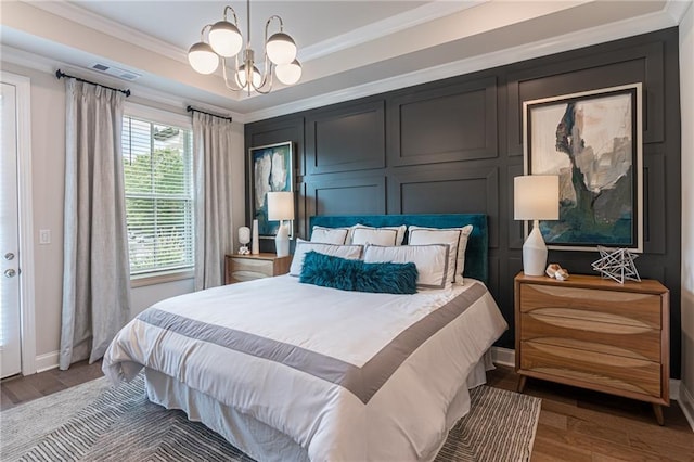 bedroom with crown molding, hardwood / wood-style flooring, and an inviting chandelier