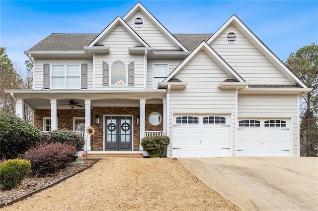 craftsman inspired home featuring a garage, french doors, ceiling fan, and covered porch