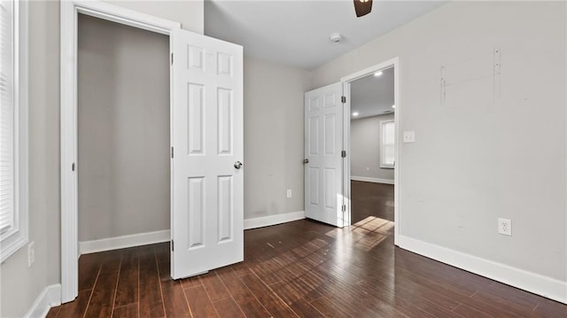 unfurnished bedroom with ceiling fan and dark hardwood / wood-style flooring