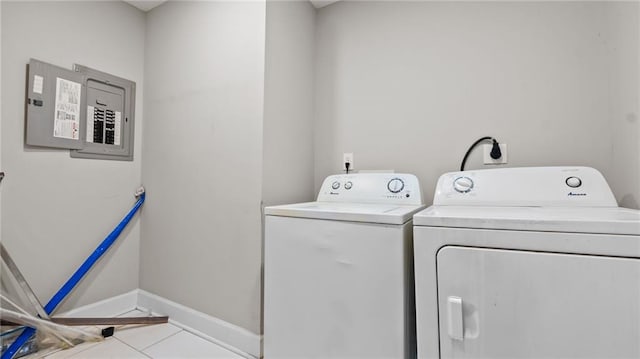 laundry room with light tile patterned floors, washing machine and clothes dryer, and electric panel