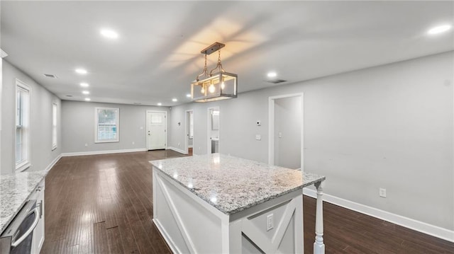 kitchen featuring decorative light fixtures, a center island, stainless steel dishwasher, dark hardwood / wood-style flooring, and white cabinets