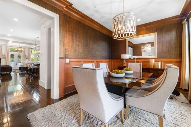 dining room with an inviting chandelier, ornamental molding, and a wainscoted wall
