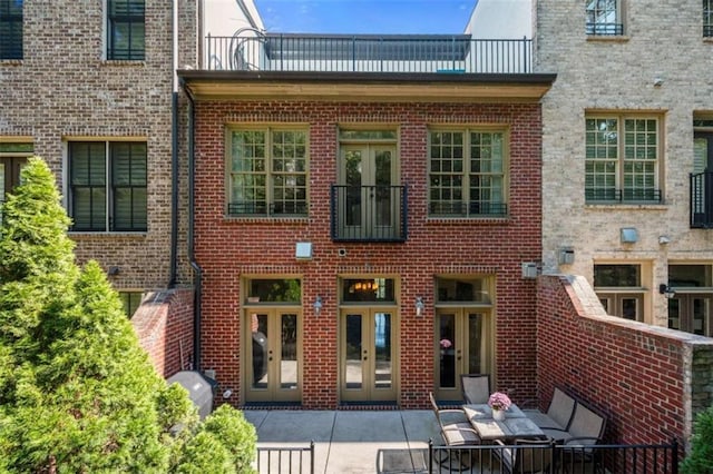 back of property with a patio area, french doors, and brick siding