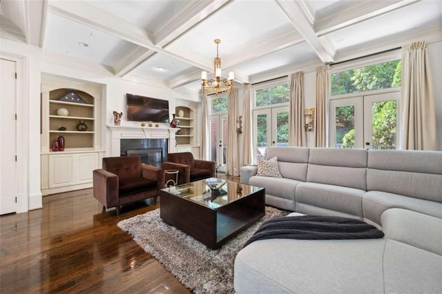 living area with dark wood-style floors, coffered ceiling, a glass covered fireplace, and french doors
