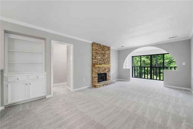 23307 Plantation Dr NE, Atlanta, GA 30324 - unfurnished living room featuring ornamental molding, baseboards, light colored carpet, a stone fireplace, and arched walkways