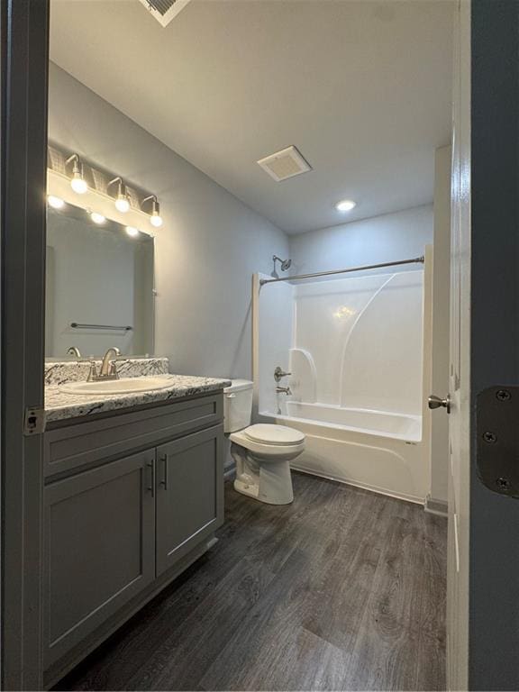 full bath featuring vanity, shower / bathing tub combination, wood finished floors, and toilet