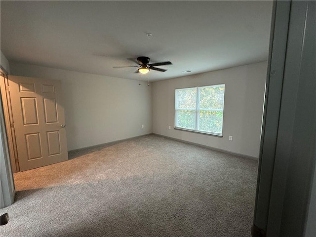 carpeted empty room featuring ceiling fan, visible vents, and baseboards