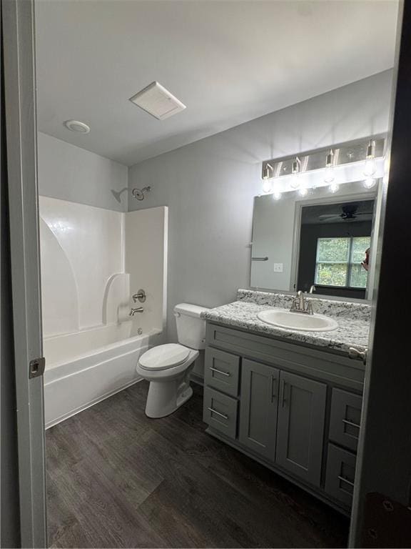 full bathroom featuring toilet, vanity, shower / bathtub combination, and wood finished floors