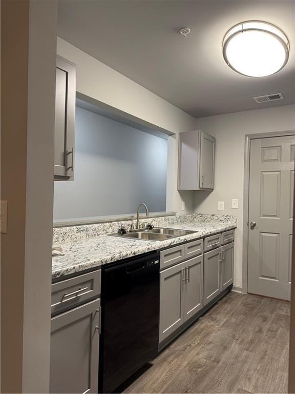 kitchen featuring gray cabinets, black dishwasher, visible vents, and a sink