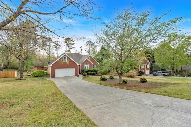traditional-style house with an attached garage, concrete driveway, a front yard, and brick siding