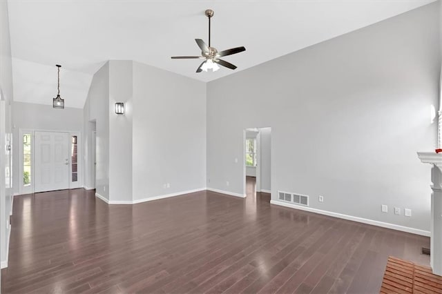 unfurnished living room with dark wood-style floors, baseboards, a ceiling fan, and visible vents