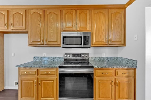 kitchen featuring appliances with stainless steel finishes, baseboards, and light stone countertops