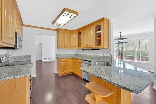 kitchen featuring visible vents, a sink, appliances with stainless steel finishes, a peninsula, and crown molding