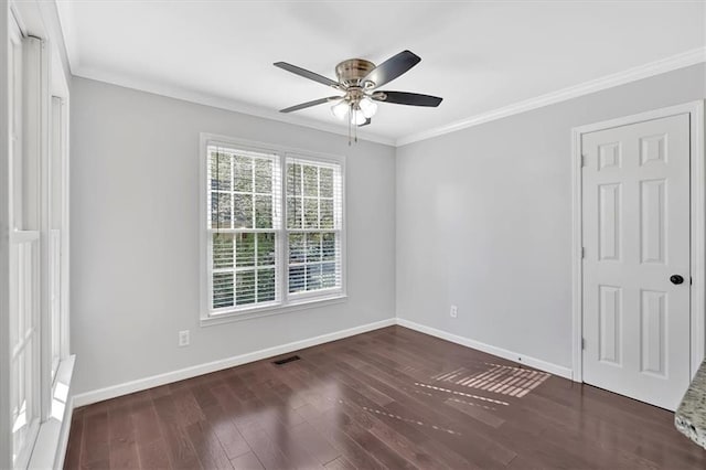 spare room featuring ceiling fan, ornamental molding, visible vents, wood finished floors, and baseboards