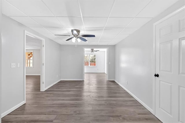 interior space with a drop ceiling, wood finished floors, and a ceiling fan