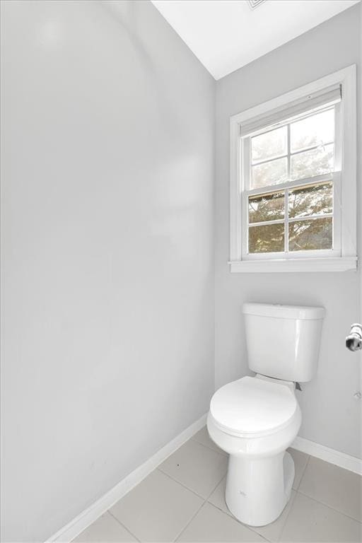 bathroom with tile patterned flooring, baseboards, and toilet