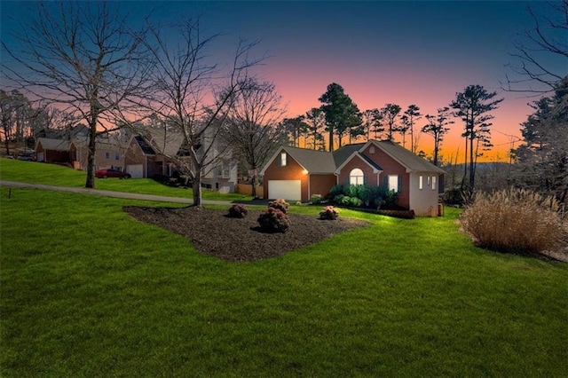 ranch-style home featuring a garage and a yard