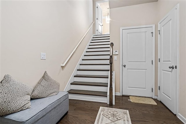 foyer featuring stairs, baseboards, and wood finished floors