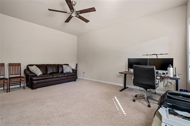 carpeted office space featuring a ceiling fan and baseboards