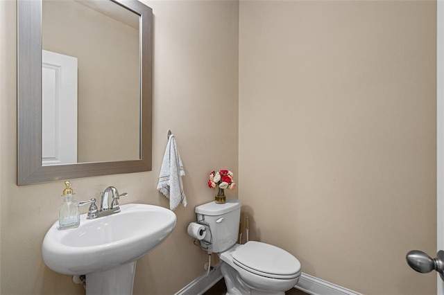 bathroom featuring a sink, toilet, and baseboards