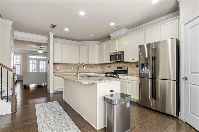 kitchen featuring dark wood-style flooring, tasteful backsplash, visible vents, appliances with stainless steel finishes, and a sink