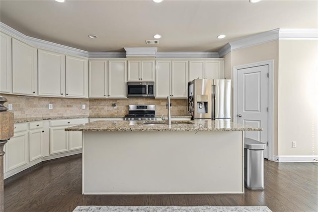 kitchen with light stone countertops, visible vents, stainless steel appliances, and dark wood-type flooring