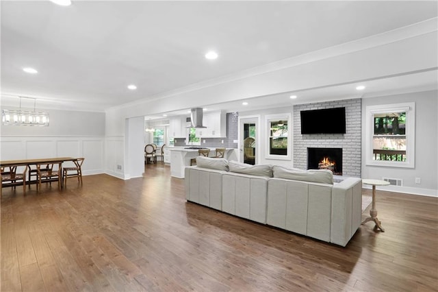 2445 Kings Point Dr, Dunwoody, GA 30338 - living room with dark wood-style floors, plenty of natural light, a fireplace, ornamental molding, and recessed lighting