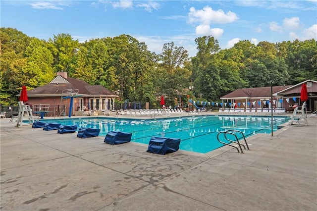 2445 Kings Point Dr, Dunwoody, GA 30338 - community pool featuring a patio and a wooded view