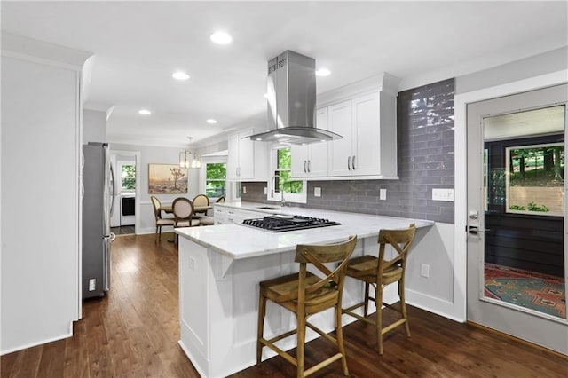 2445 Kings Point Dr, Dunwoody, GA 30338 - kitchen featuring island range hood, appliances with stainless steel finishes, white cabinets, a sink, and a peninsula
