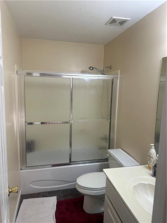 full bathroom featuring shower / bath combination with glass door, vanity, and toilet