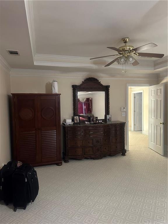 carpeted bedroom with a raised ceiling, ceiling fan, and ornamental molding