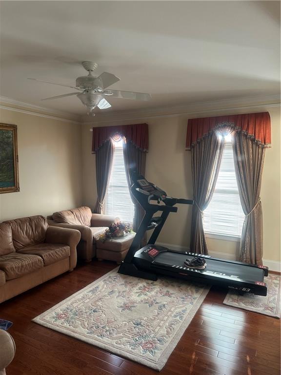 interior space with crown molding, ceiling fan, and dark hardwood / wood-style floors