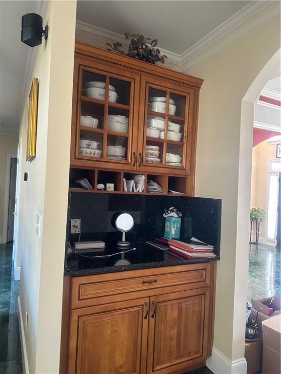 bar with backsplash, dark stone countertops, and crown molding