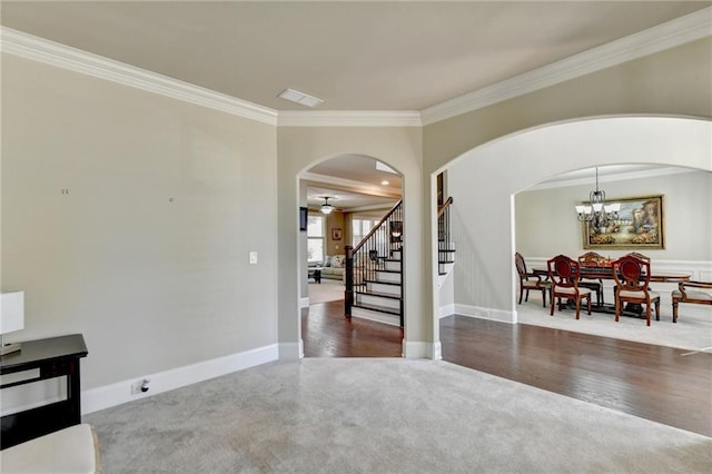 interior space featuring ceiling fan with notable chandelier, crown molding, and dark hardwood / wood-style floors