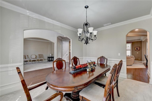 3191 Lake Mcginnis Dr, Suwanee, GA 30024 - dining area with arched walkways, ornamental molding, a chandelier, and light wood-style floors