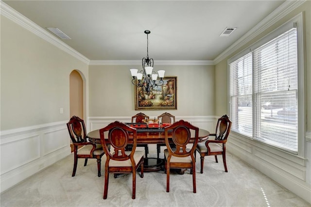 3191 Lake Mcginnis Dr, Suwanee, GA 30024 - dining area with carpet floors, a chandelier, arched walkways, crown molding, and a wainscoted wall