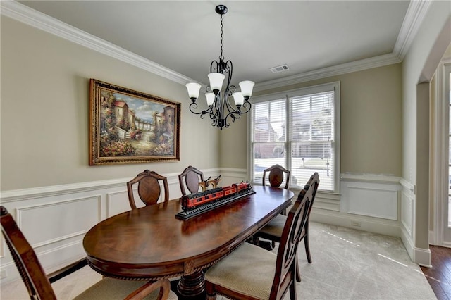 dining space featuring crown molding, wood-type flooring, and a chandelier