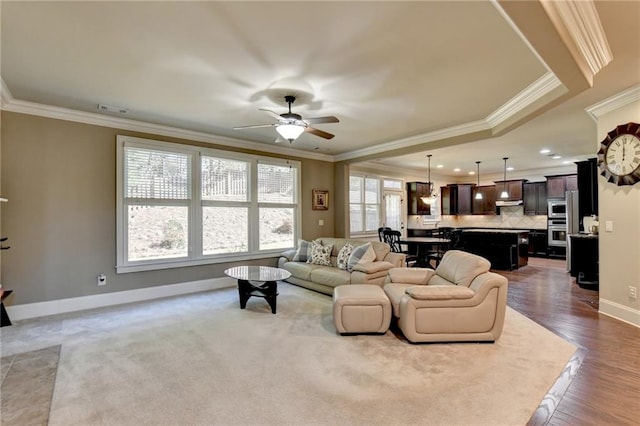 living room featuring hardwood / wood-style floors, crown molding, and ceiling fan