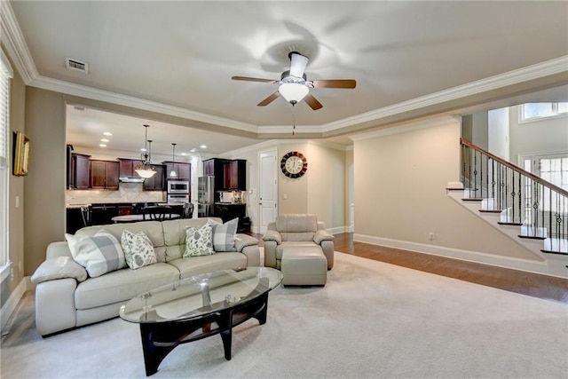 living room with ornamental molding, wood-type flooring, and ceiling fan